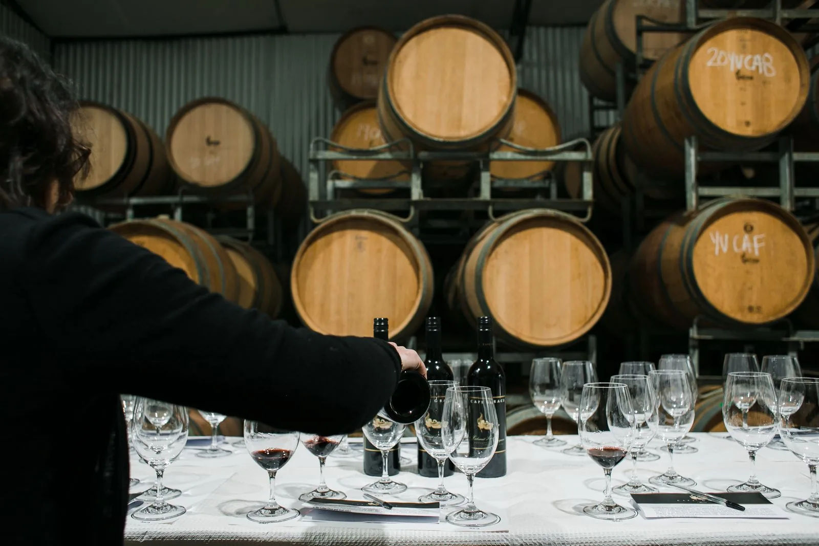 Wine tasting with barrels in the background